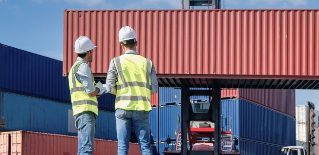 Supervisores de logística revisando contenedores de carga marítima